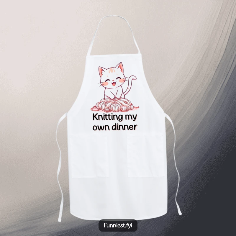 Funny apron design of a smiling cat tripping over its tail into a pile of yarn, a humorous cooking accessory for cat lovers.