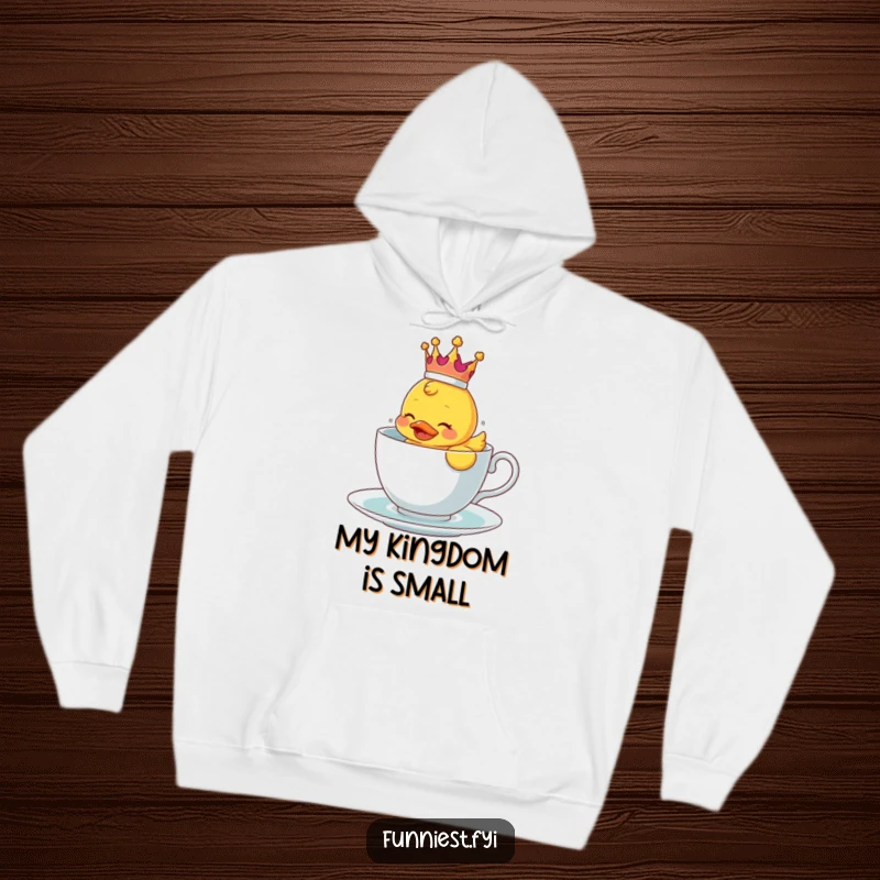 Funny hoodie with a rubber ducky wearing a crown, struggling to float in a teacup, soft and amusing.